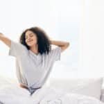 Black woman, morning stretching and waking up in home bedroom after sleeping or resting. Relax, pea