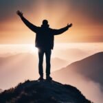 Person with arms raised on mountain at sunset.