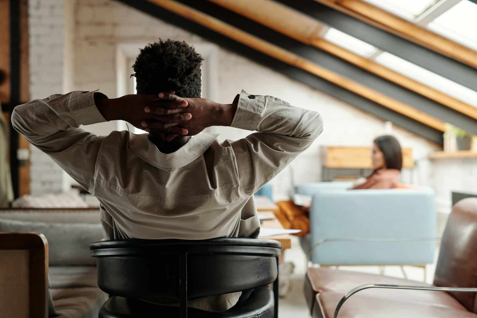 rear view of young restful african american businessman sitting in armchair Rear view of young restful African American businessman sitting in armchair